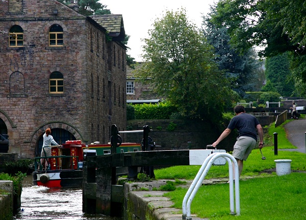 A canal boat exits Lock 9 to pass Oldknow's Warehouse